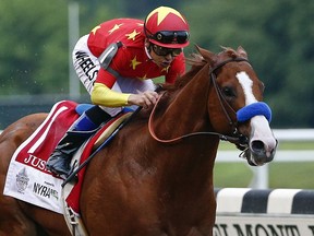 FILE - In this June 9, 2018, file photo, Justify (1), with jockey Mike Smith up, crosses the finish line to win the 150th running of the Belmont Stakes horse race and the Triple Crown in Elmont, N.Y. The undefeated Triple Crown winner has been retired from racing because of fluid in his left front ankle, trainer Bob Baffert and Justify's owners announced Wednesday, July 25, 2018. They cited caution over the horse's ankle making it impossible to tell if he'd be able to race by the fall.