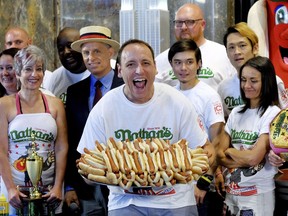 Ten-time and defending Nathan's Famous Men's Champion Joey Chestnut poses with 72 hot dogs during Nathan's Famous International Fourth of July Hot Dog Eating Contest weigh-in at the Empire State Building on Tuesday, July 3, 2018, in New York.