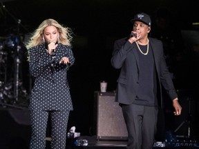 FILE - In this Nov. 4, 2016 file photo, Beyonce, center, and Jay-Z perform during a Democratic presidential candidate Hillary Clinton campaign rally in Cleveland. Beyonce and Jay-Z, who recently released a collaborative album as The Carters, are nominated for eight MTV Video Music Awards. This year's show, which returns to New York City's Radio City Music Hall on Aug. 20, 2018.