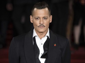 FILE - In this Nov. 2, 2017, file photo, actor Johnny Depp poses at the world premiere of the film "Murder on the Orient Express," in London. Depp has settled lawsuits with his former business managers that put a spotlight on the actor's spending. Depp's representatives said on Monday, July 16, 2018, that Depp had settled litigation filed against The Management Group, which he accused in January 2017 seeking more than $25 million over alleged financial abuse and negligence.