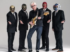 This image released by Shorefire Media shows Nick Lowe, center, with member of Los Straitjackets, from left, Chris Sprague, Eddie Angel,  Greg Townson and Pete Curry.