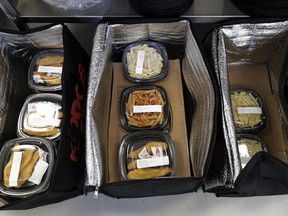 This May 10, 2018 photo shows catered lunches packed in containers to deliver to Kipling Elementary School in Highland Park, Ill. Food-delivery services are remaking school lunch. Many parents still make their kids' lunch, of course, or sign up for a hot-lunch program through school. But others are ordering from companies that deliver meals to home or school. Kiddos Catering in Chicago has come up with a different twist: providing restaurant meals to schools that contract with it.