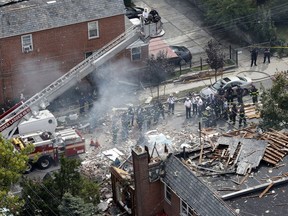FILE - In this Sept. 27, 2016 file photo, emergency service personnel work at the scene of a house explosion in the Bronx borough of New York where firefighter Michael Fahy, a 17-year fire department veteran was killed after responding to a report of a gas leak at the home. Two men pleaded guilty on Friday July 13, 2008, to manslaughter in the explosion at the marijuana grow house where the Bronx district attorney said leaking gas couldn't escape through foil-covered windows.