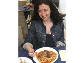 In this May 11, 2018 photo provided by Danielle Oteri, Oteri poses with a plate of pasta in Naples, Italy. Hotel and home-sharing companies don't just want to sell you a room anymore. They also want to sell you an experience. Oteri runs a company called Feast on History that gives tours in Italy and New York City and has been offering tours of Italian food shops in the Bronx since 2007. Both Marriott and Airbnb reached out to her directly about her $79 tour, which is offered on both of their web sites. But most tours are still booked through her own site.