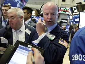 Trader Patrick Casey, center, works on the floor of the New York Stock Exchange, Monday, July 23, 2018. Stocks are opening slightly lower on Wall Street, led by declines in technology companies and retailers.