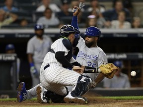 Kansas City Royals' Brian Goodwin (25) scores before New York Yankees catcher Kyle Higashioka, left, gets the ball on a single by Rosell Herrera in the sixth inning during the second baseball game of a doubleheader Saturday, July 28, 2018, at Yankee Stadium in New York.