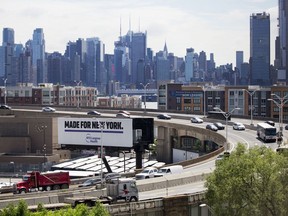 FILE - In this Thursday, June 21, 2018, file photo, traffic spirals up-and-down a section of Route 495 to the Lincoln Tunnel,  in Weehauken, N.J., with the New York City skyline in the background. New Jersey towns along the busy highway leading to the Lincoln Tunnel into New York City could see traffic jams when a bridge repair project closes a lane in each direction. It's just not clear when.