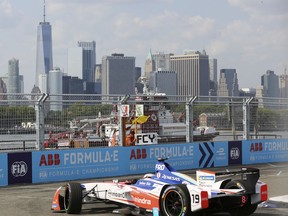 Mahindra Racing's Felix Rosenqvist drives during the first race of the Formula E championship auto race, Saturday, July 14, 2018, in the Brooklyn borough of New York. The second race will be held on Sunday. Lower Manhattan is seen in the background.