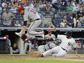 New York Yankees' Gleyber Torres (25) slides past Atlanta Braves starting pitcher Anibal Sanchez (19) to score on a wild pitch during the third inning of a baseball game Monday, July 2, 2018, in New York.