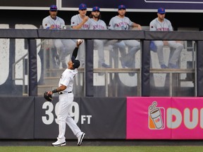 New York Yankees center fielder Aaron Hicks bare-hands an RBI double off the wall by New York Mets' Jose Bautista during the first inning of a baseball game Friday, July 20, 2018, in New York.