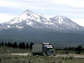 FILE -- In this June 19, 2008, file photo a truck drives past Mount Shasta near Weed, Calif. California and 14 other states are suing the Trump administration over its decision to suspend an Obama-era rule aimed at limiting pollution from trucks. The lawsuit filed Thursday, July 19, 2018, in the U.S. Court of Appeals for the District of Columbia Circuit says the July 6 decision by the Environmental Protection Agency was illegal and could put thousands of additional highly polluting trucks on the roads.