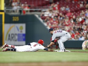 Cincinnati Reds' Billy Hamilton (6) gets back to first on a pick-off attempt as Chicago White Sox's Matt Davidson (24) takes the throw during the seventh inning of a baseball game, Monday, July 2, 2018, in Cincinnati.