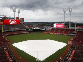 Spectators wait in the stands during a rain delay before a baseball game between the Cincinnati Reds and the Pittsburgh Pirates, Friday, July 20, 2018, in Cincinnati.