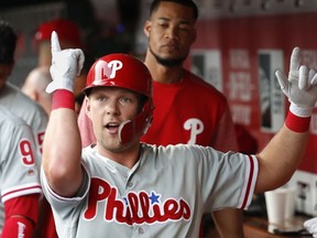 Philadelphia Phillies' Rhys Hoskins celebrates in the dugout after hitting a solo home run off Cincinnati Reds starting pitcher Tyler Mahle during the first inning of a baseball game, Thursday, July 26, 2018, in Cincinnati.