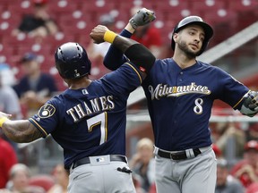 Milwaukee Brewers' Ryan Braun (8) celebrates hits two-run home run off Cincinnati Reds relief pitcher Raisel Iglesias in the ninth inning of a baseball game, with teammate Eric Thames, Sunday, July 1, 2018, in Cincinnati.