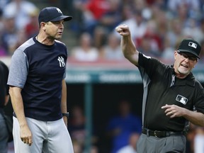 New York Yankees manager Aaron Boone, left, is ejected from a baseball game by umpire Jerry Meals after arguing a strike-out by Giancarlo Stanton during the sixth inning of a baseball game against the Cleveland Indians, Saturday, July 14, 2018, in Cleveland.