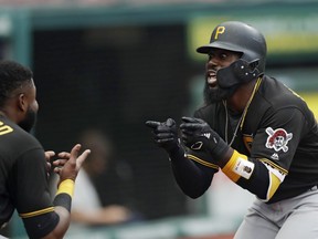 Pittsburgh Pirates' Josh Harrison, right, celebrates with Gregory Polanco after hitting a three-run home run in the second inning of a baseball game against the Cleveland Indians, Monday, July 23, 2018, in Cleveland. Josh Bell and David Freese scored on the play.