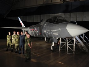 Canadian Forces pilots and ground crew pose for a photo next to the Lockheed Martin Joint Strike Fighter, F-35 Lighting II in a hanger in Ottawa Friday July 16, 2010.