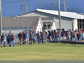 Employees evacuate the area following an incident Thursday, July 19, 2018, at Letterkenny Army Depot in Chambersburg, Pa.. A small explosion Thursday in a vehicle shop at the Army depot injured at least four workers, three of them seriously, officials said.