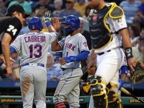 New York Mets' Asdrubal Cabrera (13) celebrates with Amed Rosario (1) near Pittsburgh Pirates catcher Francisco Cervelli, right, as Cabrera returns to the dugout after hitting a two-run home run off Pirates starting pitcher Nick Kingham during the fourth inning of a baseball game in Pittsburgh, Thursday, July 26, 2018.