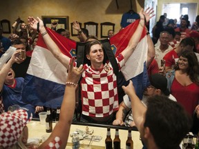 Marko Luketich Kochis, center, raises the flag Croatia as he celebrates that his team is in the World Cup soccer final against France as people gather to watch the televised game Sunday, July 15, 2018, at Croatian National Hall Javor in Pittsburgh.