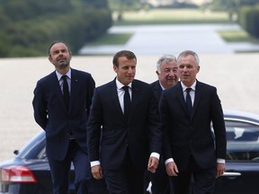French Prime Minister Edouard Philippe, left, French President Emmanuel Macron, second left, Senate house speaker Gerard Larcher and National Assembly president Francois de Rugy, right, arrive for the Versailles congress at the Versailles castle, west of Paris, Monday July 9, 2018.
