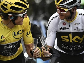 Britain's Geraint Thomas, left, wearing the overall leader's yellow jersey and Britain's Christopher Froome toast with Champagne during the 21st and last stage of the 105th edition of the Tour de France cycling race between Houilles and Paris Champs-Elysees, Sunday, July 29, 2018.