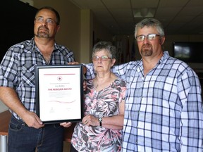 Chris, left to right, Hazel and Howard Bullen hold the Canadian Red Cross Rescuer Award presented posthumously to their father and husband, Leo Bullen, in St. John's on Tuesday, July 17, 2018. Bullen died during a marine accident in 1972 when he gave his lifejacket to a young girl.