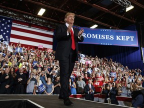 FILE - In this July 5, 2018, file photo, three of the four Roman Catholic priests are visible in the front row at lower left as President Donald Trump arrives to speak during a rally at the Four Seasons Arena at Montana ExpoPark in Great Falls, Mont. A Roman Catholic bishop in Montana criticized four priests who attended Trump's rally in Great Falls last week for wearing their black clerical garb while prominently seated in the front row directly behind the president.