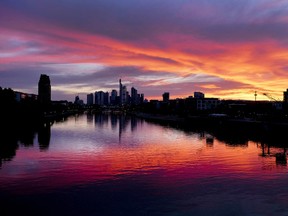 The sun sets over the banking district and the river Main in Frankfurt, Germany, late Wednesday, July 4, 2018.