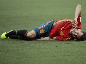 Spain's Nacho lies on the pitch after being tackled during the round of 16 match between Spain and Russia at the 2018 soccer World Cup at the Luzhniki Stadium in Moscow, Russia, Sunday, July 1, 2018.