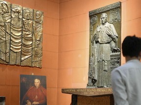 In this June 16, 2018 photo, a tourist visits the tomb of World War II-era head of Poland's Catholic Church, Cardinal August Hlond, in St. John's Arch-Cathedral in Warsaw, Poland. Pope Francis decision to move the World War II-era head of Polands Catholic Church a step closer to possible sainthood has hit a stumbling block after two leading Jewish organizations and even some Polish Catholic publications have called him out for his views seen as anti-Semitic. Its not clear if the protests will derail the sainthood cause of Cardinal August Hlond, but in the past the Vatican has taken such protests seriously and at the very least put the cases up for closer review.