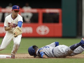 Los Angeles Dodgers' Manny Machado, right, steals second base past Philadelphia Phillies shortstop Scott Kingery during the first inning of a baseball game, Wednesday, July 25, 2018, in Philadelphia.