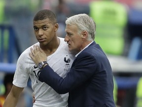 France's Kylian Mbappe, left, is embraced by France head coach Didier Deschamps as he leaves the pitch during the quarterfinal match between Uruguay and France at the 2018 soccer World Cup in the Nizhny Novgorod Stadium, in Nizhny Novgorod, Russia, Friday, July 6, 2018.
