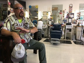 In this Tuesday July 17, 2018 photo, James Flaskey, 74, an U.S. Army veteran, discusses President Donald Trump's recent comments about Russian meddling in American elections at a barbershop in Norfolk, Va.