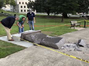 FILE - In this June 28, 2017 file photo, personnel from the Secretary of State's office inspect damage to the new Ten Commandments monument outside the state Capitol in Little Rock, Ark., after Michael Tate Reed crashed into it with a vehicle. A judge on Friday, June 28, 2018, approved the conditional release of Reed from the state hospital to live with his mother in Alma, Ark., weeks after he was acquitted on mental health grounds.