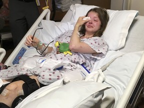 Jessica Tilton wipes away tears while interviewed from a hospital bed about an explosion caused by lava oozing into the ocean that sent molten rock crashing through the roof of a sightseeing boat she was on in Honolulu, Tuesday, July 31, 2018. The July 16, 2018 accident left her with a broken thigh bone, broken pelvis and other injuries.