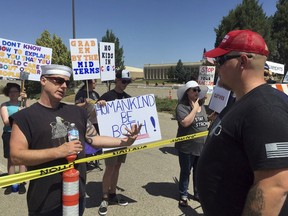 People on opposing sides of issues talk, among thousands of people lined up hours before President Donald Trump was scheduled to speak in Great Falls, Mont., on Thursday, July 5, 2018. Trump is holding a rally to campaign for U.S. Sen. Jon Tester's Republican challenger, State Auditor Matt Rosendale.