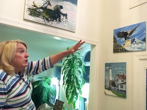 Former Department of Correction counselor Patricia May describes some of the many paintings by Delaware prison inmates that decorate her home in Hockessin, Del., Monday, July 16, 2018. May, a state corrections counselor who was taken hostage during a deadly riot at Delaware's maximum-security prison, says prison officials are to blame. On Tuesday, Gov. John Carney and corrections officials will release a final report on efforts to implement 41 recommendations from an independent review team.