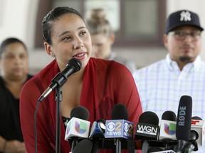 Mia Irizarry speaks at a news conference in Chicago, Friday, July 13, 2018, about an incident where a man confronted her about a T-shirt she wore emblazoned with the Puerto Rican flag at a Chicago forest preserve on June 14. Irizarry says a forest preserve police officer who appeared to ignore her pleas for help only intervened to tell someone else to "calm down." The man who confronted her has been charged with a hate crime and the officer has quit his job.