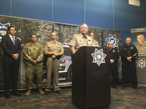 Arizona Department of Public Safety Director Col. Frank Milstead speaks at a news conference in Phoenix on Thursday, July 26, 2018, while flanked by officers and a picture of slain DPS Trooper Tyler Edenhofer. Authorities say a male suspect used a state trooper's gun and fatally shot Edenhofer and wounded another trooper Wednesday night after reports of someone throwing rocks at vehicles.