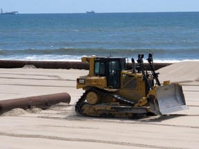 This July 13, 2018 photo shows a bulldozer smoothing sand in a beach replenishment project in Surf City, N.J. Some residents and visitors complain about noise and disruption from the replenishment work and wish it could be prohibited during the summer, even as they acknowledge the need for it.