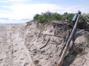 This July 31, 2018 photo shows a cut-through that was bulldozed a day earlier through a 40-year-old sand dune in Berkeley Township, N.J. as part of a beach replenishment project. New Jersey and federal officials said in court last year they would not shorten the dunes. The U.S. Army Corps of Engineers says the flattened sand is only temporary and will be restored, but residents who built and maintained the dune were enraged by the damage, with one standing in front of a bulldozer before police got him to move.