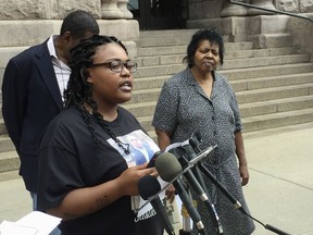 Sydney Brown, the cousin of Thurman Blevins, is joined other family members and activists Monday, July 9, 2018, to call for criminal charges against two Minneapolis police officers who fatally shot Blevins on June 23, 2018. Looking on are community activist Mel Reeves, left, and Blevins' aunt Jeanette Blevins, right.