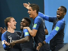 France's Samuel Umtiti, second from left, is congratulated by teammates Antoine Griezmann, Raphael Varane and Paul Pogba, from left, after scoring the only goal of France's 1-0 World Cup semifinal victory over Belgium in St. Petersburg, Russia on Tuesday, July 10, 2018.