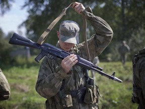 In this file photo taken on Wednesday, Aug. 2, 2017 a Russian soldier prepares for a team's run at the Army Scout Masters competition, part of Army Games, outside Novosibirsk, 2900 kilometres east of Moscow, Russia.