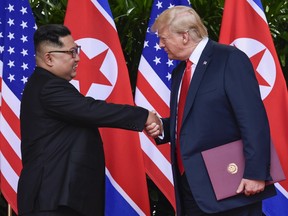 FILE - In this June 12, 2018, file photo, North Korea leader Kim Jong Un, left, and U.S. President Donald Trump shake hands at the conclusion of their meetings at the Capella resort on Sentosa Island in Singapore. Three weeks after the U.S.-North Korea summit and ahead of an impending trip to North Korea by U.S. Secretary of State Mike Pompeo, a leaked U.S. intelligence report and an analysis of satellite data suggest the North may be continuing its nuclear and missile activities despite a pledge to denuclearize.