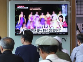 A TV screen shows a blurred photo of North Korean restaurant workers in China, during a news program at the Seoul Railway Station in Seoul, South Kore, Friday, July 20, 2018. North Korea said that an August reunion of Korean families separated by war may not happen if South Korea doesn't immediately return some of its citizens who arrived in the South in recent years. The signs read: "The two Koreas agreed to hold a reunion of Korean families."