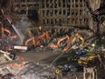In this Nov. 7, 2001 file photo, workers and heavy machinery continue the cleanup and recovery effort in front of the remaining facade of 1 World Trade Center at ground zero in New York.