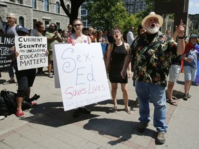 People shout at a protest to changes in Ontario's sex-ed curriculum at the Human Rights Monument in Ottawa on Sunday, July 15, 2018. But the idea that this curriculum — and only this curriculum — is the difference between LGBTQ people being viciously persecuted and being respected as human beings is ridiculous.
